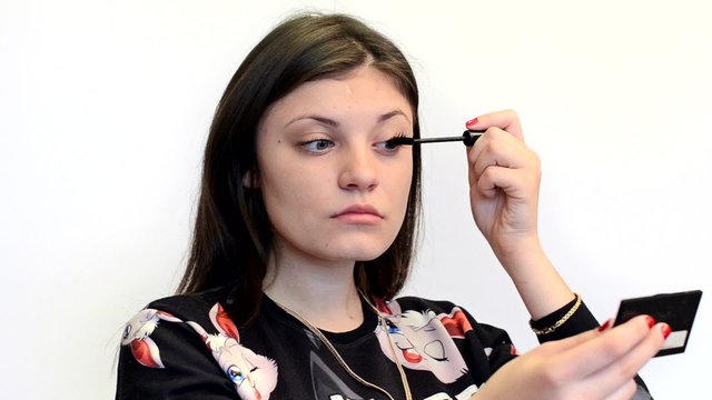 Девушка красит ресницы тушью. Видео с белым фоном. 
