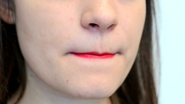 Девушка поправляет макияж на губах крупный план.