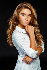 Portrait beautiful young brunette woman with wavy hair in white 