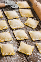 Raw ravioli on wooden background