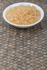 Brown sugar in white bowl over wicker background