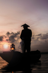 Fisherman cleaning a net after cast a net in Bangpra lake, Thail