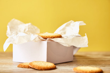 White gift box with cookies on bright yellow background