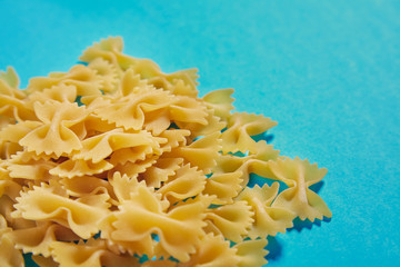 Many italian farfale pasta in corner on ble background