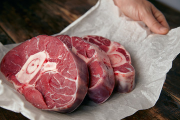 Closeup of three cosher meat steaks with bone for dinner - obrazy, fototapety, plakaty
