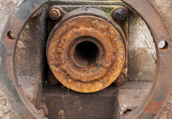 End of axle in old rusty industrial machine.