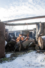 Cooking in field conditions, boiling pot at the campfire on picnic in the mountain