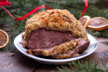 Roasted beef with bread crust sliced on plate