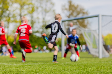 Obraz na płótnie Canvas Blurred kids playing soccer match