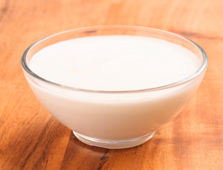 Obraz na płótnie Canvas bowl full of yogurt on wood