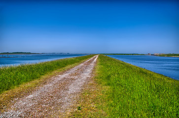 Country road surrounded by water, Holland, Netherlands, HDR