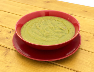 Pea and ham soup in a red bowl
