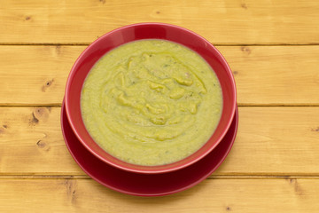 Bowl of green soup in a red bowl