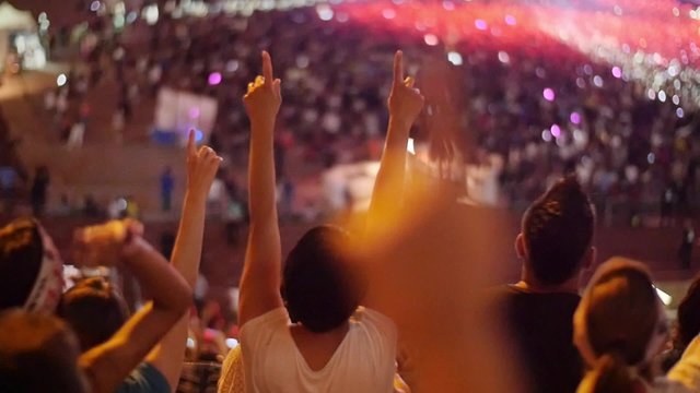Handheld shot of a crowd making party at a rock concert. Slow motion