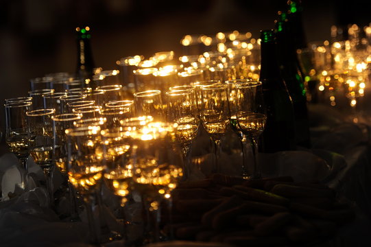 Champagne flautes prepared for a wedding reception with a ray of light