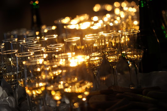 Champagne flautes prepared for a wedding reception with a ray of light