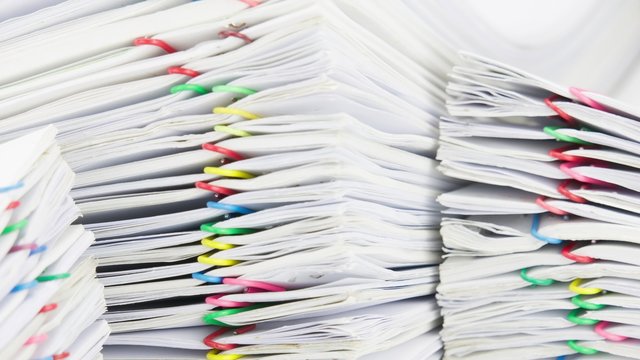 Close up colorful paper clip with pile of report time lapse