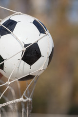 Football, soccer ball in goal net