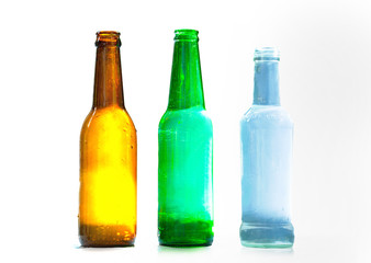 Different bottles with water drops on white background