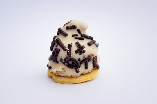 Chocolate artesanal blanco con chispitas de chocolate artesanal cuencano negro y relleno de licor, sobre galleta de mantequilla