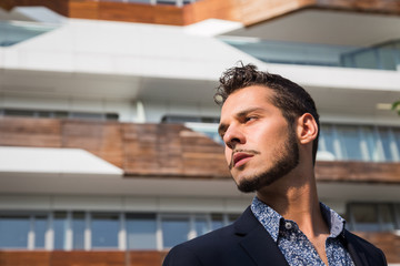 Fototapeta premium Young handsome man posing in the city streets