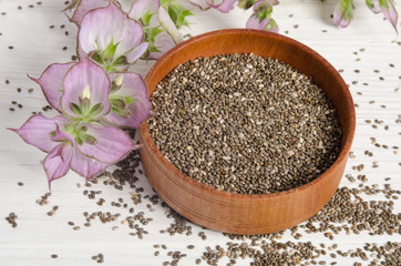 Chia seed healthy super food with flower over white wood backgro
