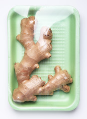 Fototapeta premium Image of plastic pack of ginger root from store on white backgro