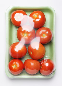 Image of plastic pack of tomatoes from store on white background