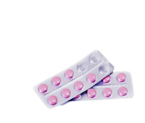 Pink medical pills on white table