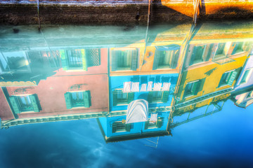 colorful buildings reflected on the water in Burano