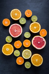 Citrus half cut fruits on dark background