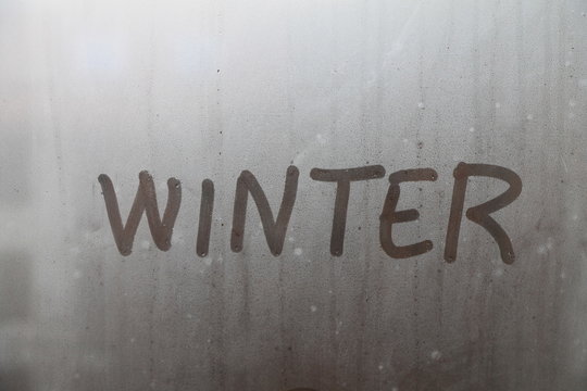 Word winter written on glass