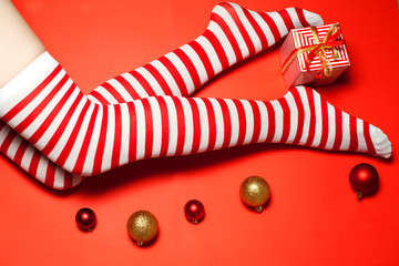 Sexy Santa woman legs with Christmas balls and gift