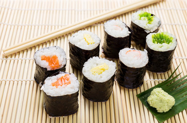 Salmon, egg and vegetable sushi rolls with sauce and wasabi