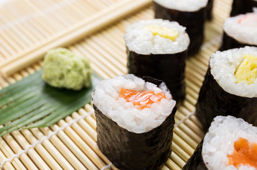 Salmon, egg and vegetable sushi rolls with sauce and wasabi
