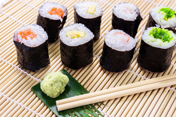 Salmon, egg and vegetable sushi rolls with sauce and wasabi