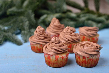 cupcakes with chocolate cream on a blue wooden background
