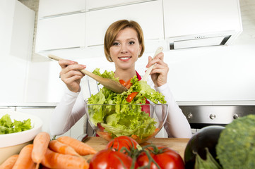 young beautiful home cook woman at modern kitchen preparing vegetable salad bowl smiling happy