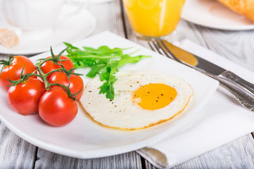 Breakfast with cup of coffee, egg and orange juice on wooden table

