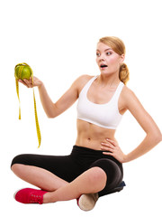 Joyful woman holds grapefruit and measurement tape