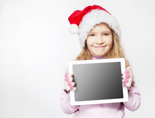Child in christmas hat with tablet