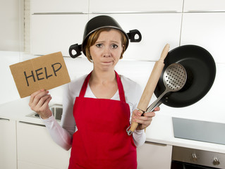 young attractive home cook woman in red apron at  kitchen holding pan and household with pot on her head in stress