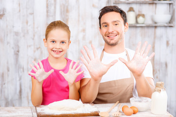 Happy father and daughter baking together 