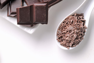 Chocolate chips and portions on white containers close up top