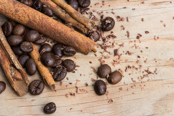 chocolate, cinamon and coffee beans on wooden table.