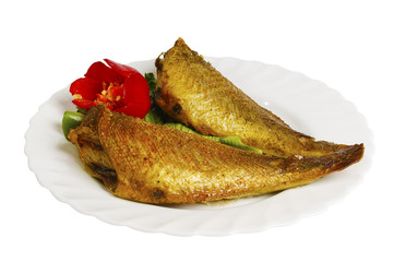 grilled fish with greens on the plate, isolated