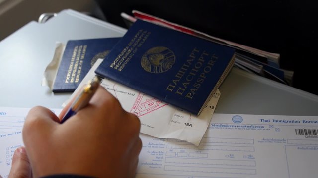 Closeup of Filling Immigration Card with Passports 