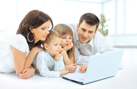 family looking into the laptop enthusiastically