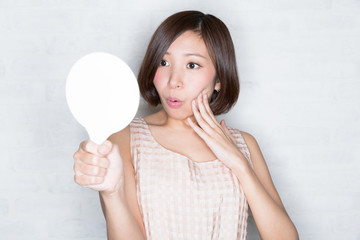 お肌のハリをチェックする女性