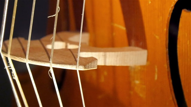 Closer view of the strings of the violin placed on the room 